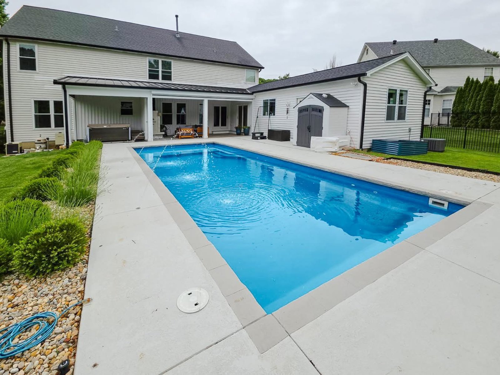 Modern residential swimming pool with deck jets serviced by Blue Anchor in Florissant, MO